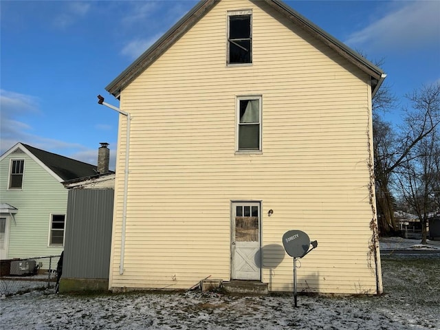 view of snow covered back of property