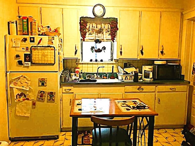 362 Randolph St, Meadville, PA 16335 - kitchen with freestanding refrigerator, black microwave, dark countertops, and backsplash