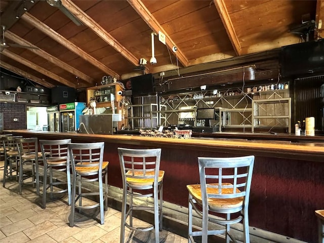 bar featuring vaulted ceiling with beams, tile patterned flooring, and wooden ceiling