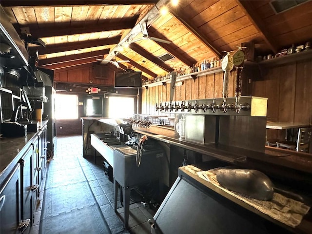 kitchen featuring vaulted ceiling with beams, wood walls, and wood ceiling