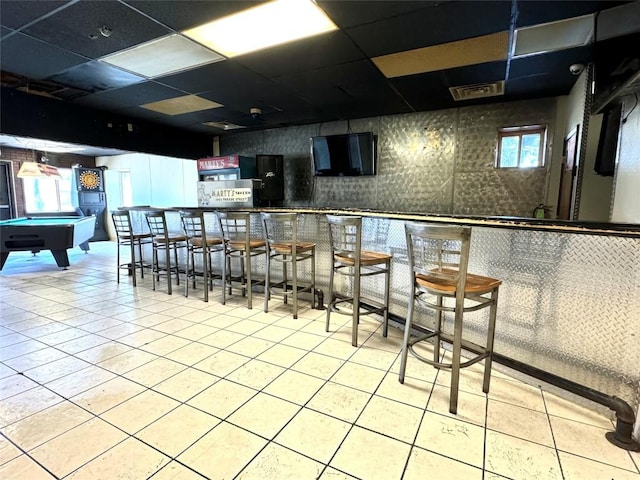 bar featuring a paneled ceiling, light tile patterned flooring, and pool table