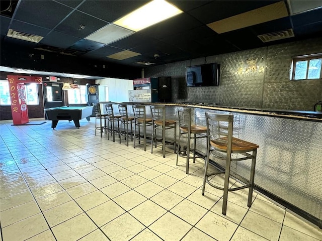 interior space with a paneled ceiling, tile patterned floors, and pool table