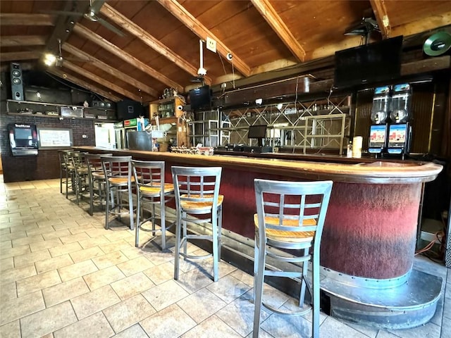 bar featuring vaulted ceiling with beams, tile patterned floors, wooden ceiling, and brick wall