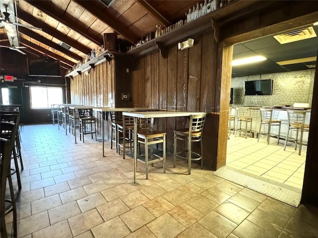 interior space featuring lofted ceiling with beams, wood walls, and wooden ceiling