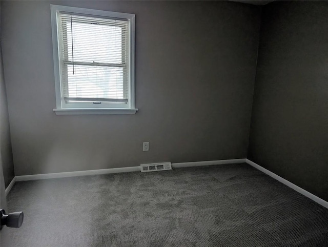 carpeted spare room featuring visible vents and baseboards