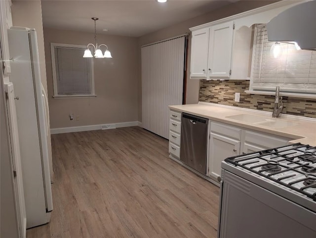 kitchen featuring decorative backsplash, white appliances, hanging light fixtures, white cabinets, and sink