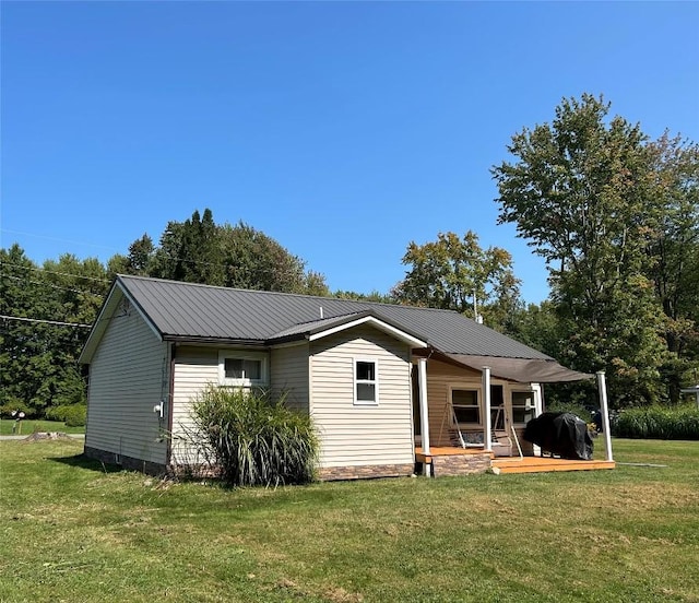 back of property featuring a lawn and covered porch