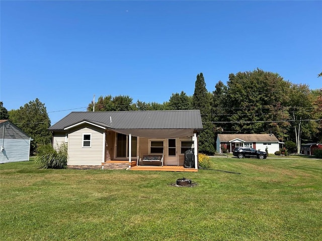 back of house with covered porch and a yard