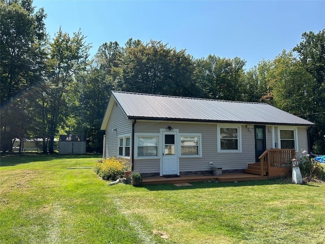 view of front facade with a front yard, a deck, and a storage shed