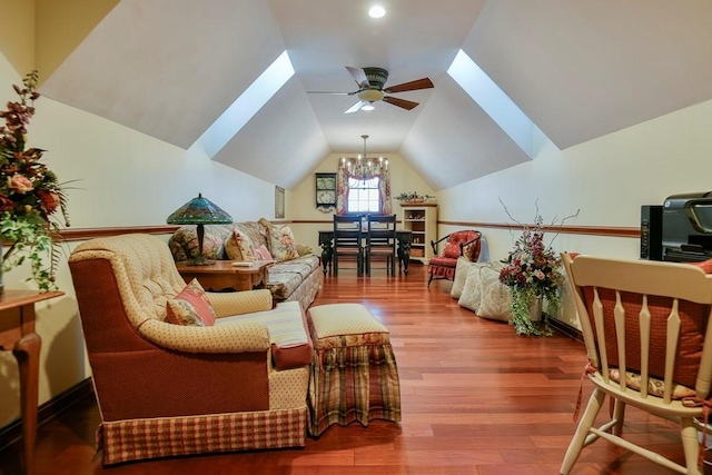 sitting room featuring ceiling fan with notable chandelier, hardwood / wood-style floors, and lofted ceiling with skylight