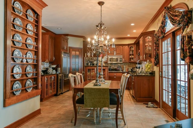 tiled dining room with french doors, crown molding, and a chandelier