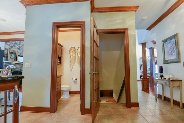 hallway with ornamental molding and light tile patterned floors