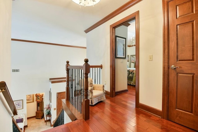 hallway featuring ornamental molding and hardwood / wood-style floors