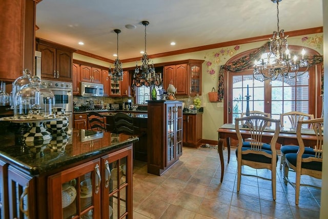 kitchen with decorative light fixtures, a center island, an inviting chandelier, french doors, and appliances with stainless steel finishes