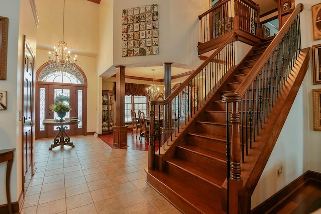 foyer entrance with a high ceiling, light tile patterned flooring, and a notable chandelier