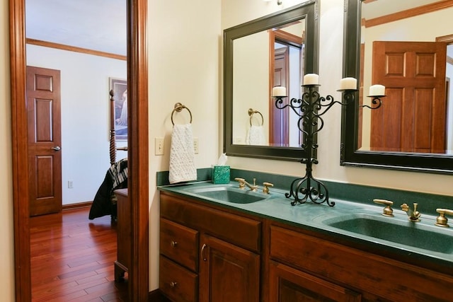 bathroom featuring crown molding, wood-type flooring, and vanity