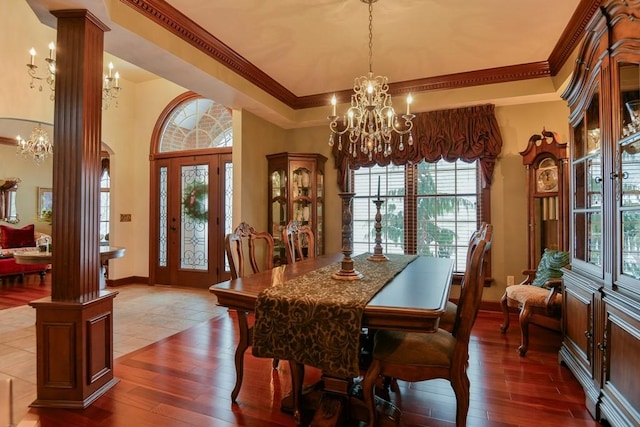 dining room featuring ornate columns, wood-type flooring, and ornamental molding