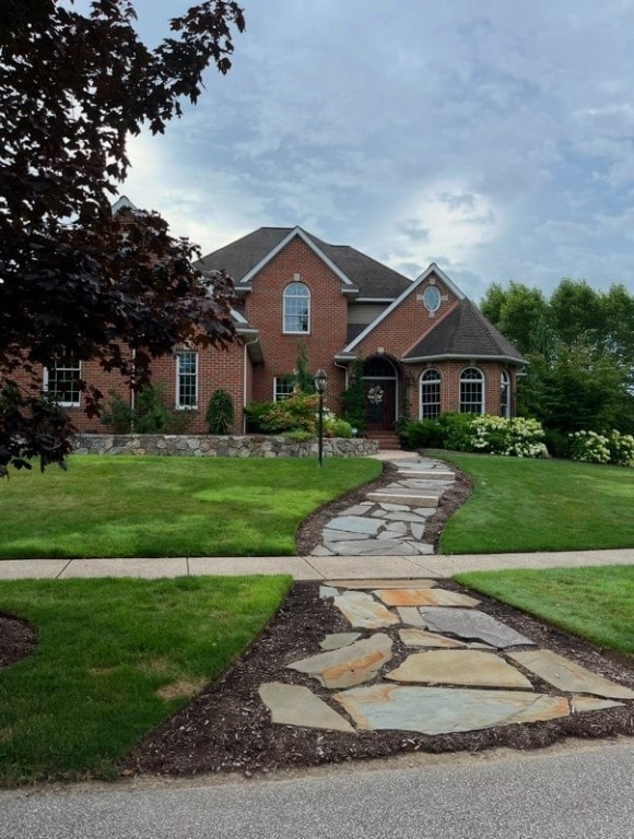 traditional home featuring brick siding and a front yard