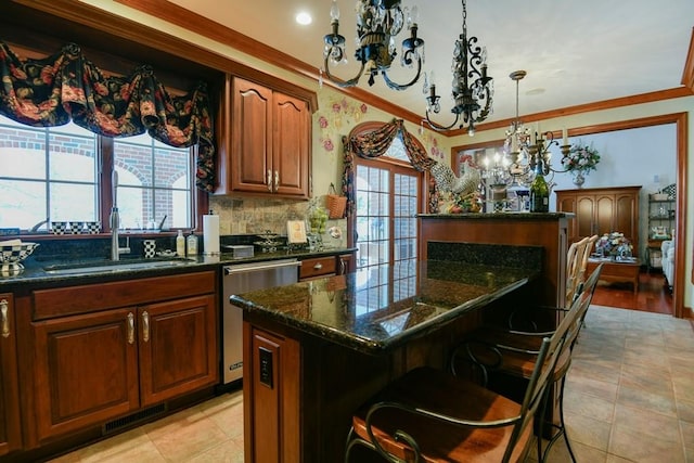 kitchen featuring sink, a center island, a kitchen bar, ornamental molding, and stainless steel dishwasher