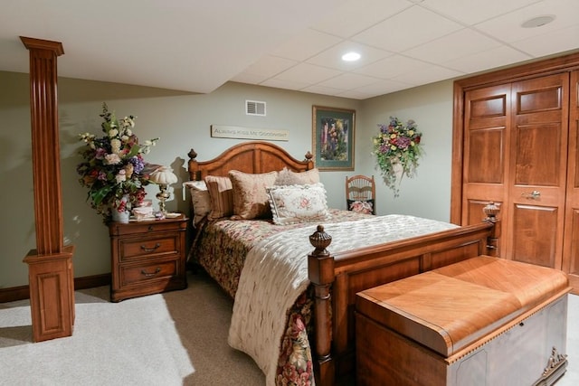 carpeted bedroom with a paneled ceiling and ornate columns