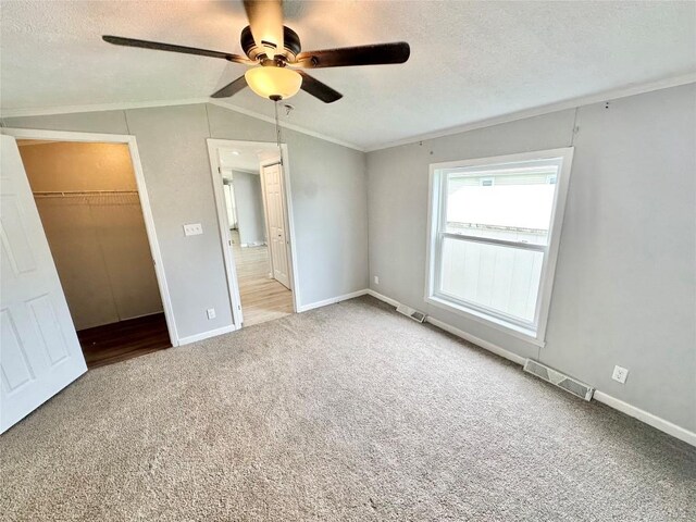 10644 W Main Rd Unit 45, North East, PA 16428 - unfurnished bedroom with carpet flooring, crown molding, vaulted ceiling, a textured ceiling, and a ceiling fan
