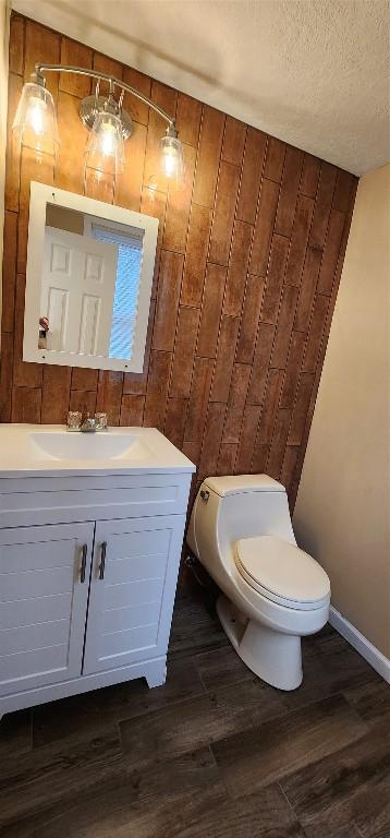 bathroom featuring toilet, vanity, a textured ceiling, and hardwood / wood-style flooring