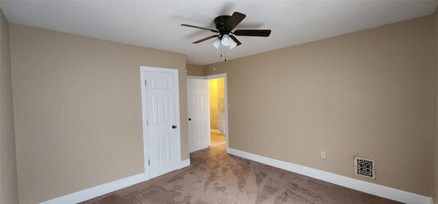 empty room with ceiling fan and light colored carpet