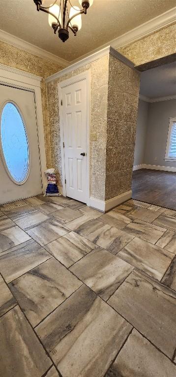 foyer featuring crown molding and a notable chandelier