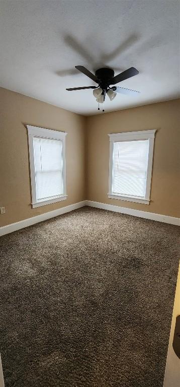 empty room featuring ceiling fan and a wealth of natural light