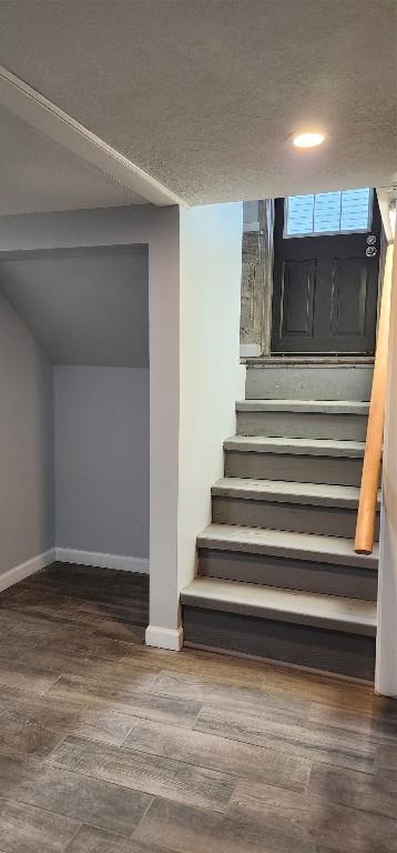 staircase with a textured ceiling