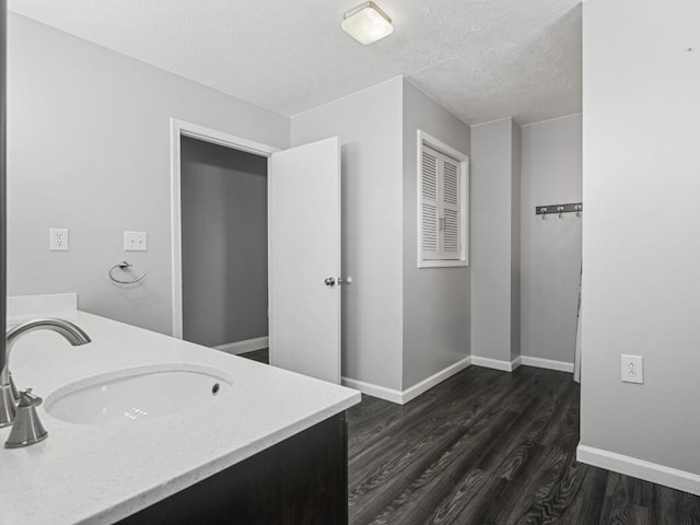 11350 State Highway 618, Conneaut Lake, PA 16316 - bathroom with wood finished floors, a textured ceiling, double vanity, and baseboards
