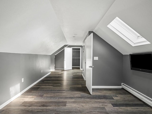 11350 State Highway 618, Conneaut Lake, PA 16316 - additional living space with a baseboard radiator, a skylight, vaulted ceiling, baseboards, and wood finished floors
