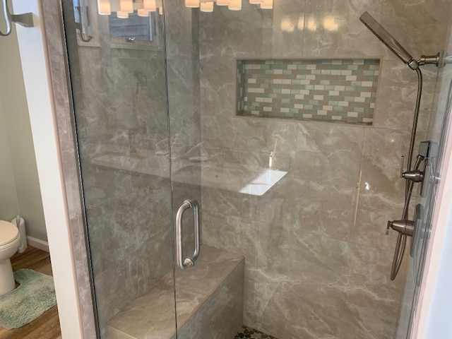 11148 Aldina Dr, Conneaut Lake, PA 16316 - bathroom featuring a shower stall, toilet, wood finished floors, and baseboards