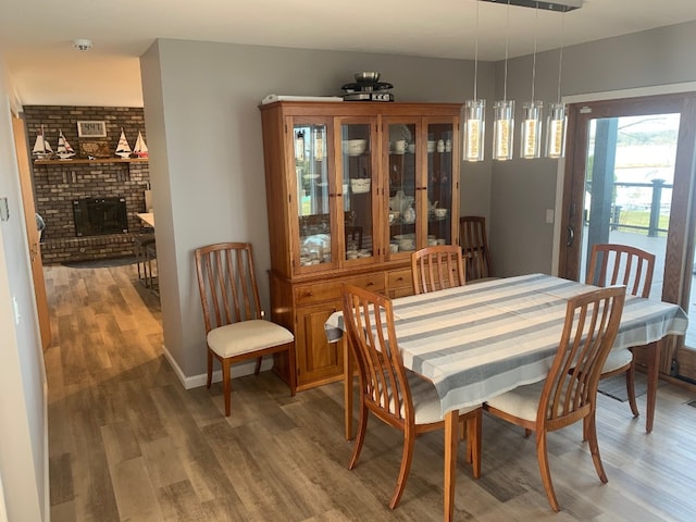 11148 Aldina Dr, Conneaut Lake, PA 16316 - dining room with light wood-style flooring, a fireplace, and baseboards