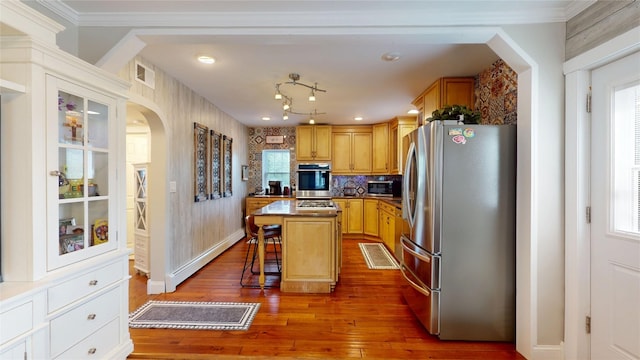 1450 Nicholson St, Erie, PA 16509 - kitchen featuring stainless steel appliances, arched walkways, wood-type flooring, a kitchen island, and a kitchen breakfast bar