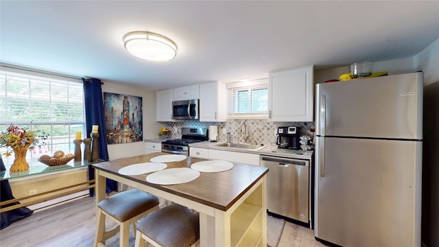1450 Nicholson St, Erie, PA 16509 - kitchen featuring stainless steel appliances, healthy amount of natural light, light wood finished floors, and decorative backsplash