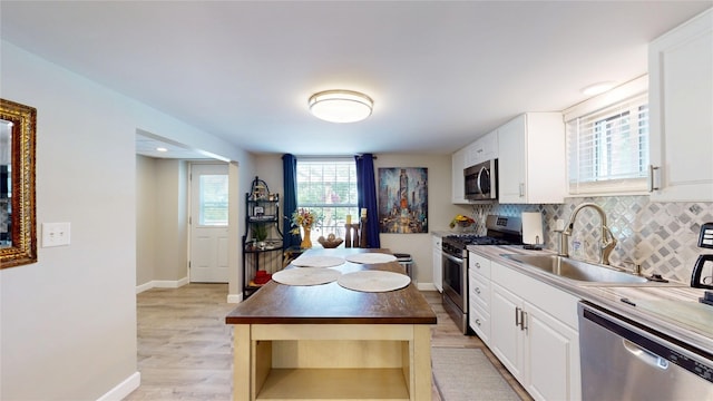 1450 Nicholson St, Erie, PA 16509 - kitchen featuring stainless steel appliances, backsplash, white cabinets, light wood-style flooring, and dark countertops