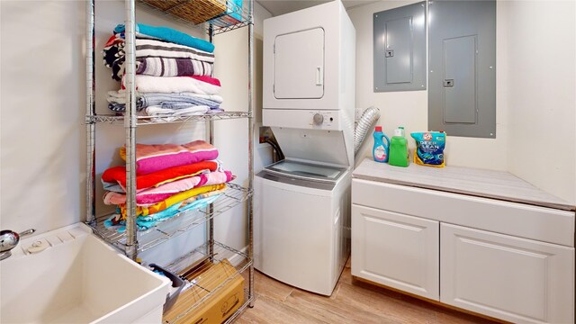 1450 Nicholson St, Erie, PA 16509 - laundry room featuring stacked washer / drying machine, electric panel, cabinet space, and light wood-style floors