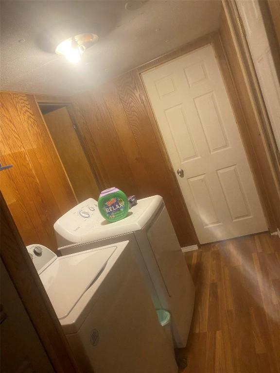 clothes washing area featuring washing machine and dryer and wood-type flooring