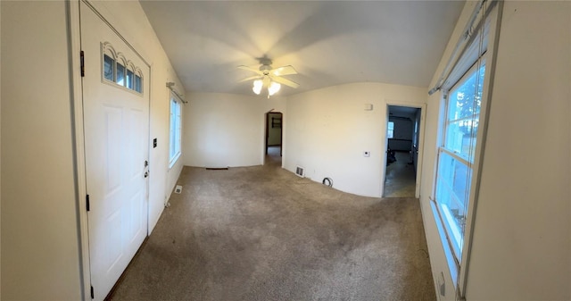 carpeted spare room featuring a ceiling fan and vaulted ceiling