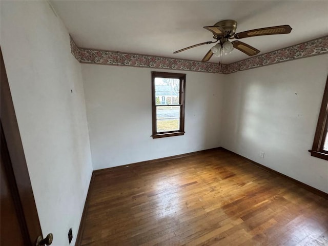 spare room with ceiling fan, baseboards, and hardwood / wood-style floors