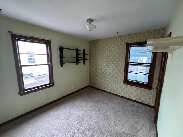 spare room with wallpapered walls, baseboards, and carpet flooring