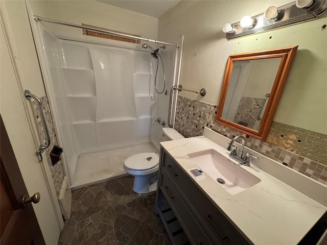 bathroom featuring a shower, backsplash, vanity, and toilet