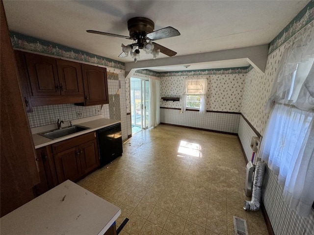 kitchen featuring black dishwasher, light countertops, visible vents, a sink, and wallpapered walls