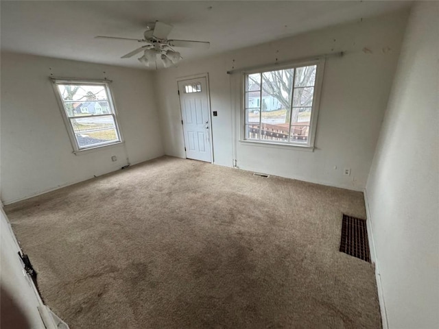 interior space featuring carpet floors, ceiling fan, and visible vents