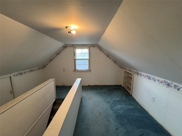 bonus room with lofted ceiling and dark carpet