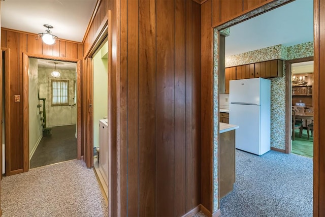 corridor featuring carpet floors and wooden walls