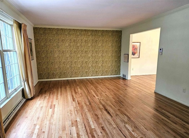 spare room with hardwood / wood-style flooring, crown molding, and a baseboard radiator