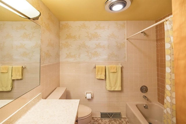 full bathroom featuring toilet, vanity, tile walls, tile patterned flooring, and shower / bath combination with curtain