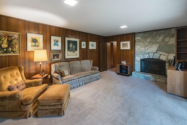 living area featuring built in features, carpet flooring, and a fireplace